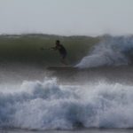 Harris surfing his otter wooden paddleboard