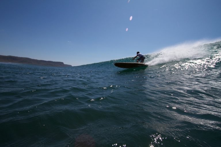 Harris surfing his otter wooden paddleboard