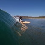 Harris surfing his otter wooden paddleboard