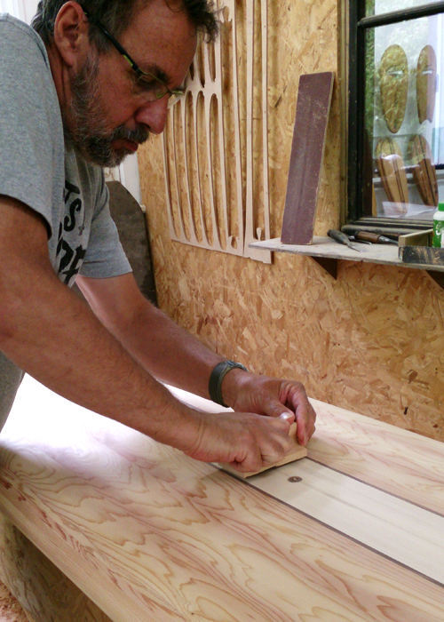 glenn stamping his wooden surfboard in the otter workshop