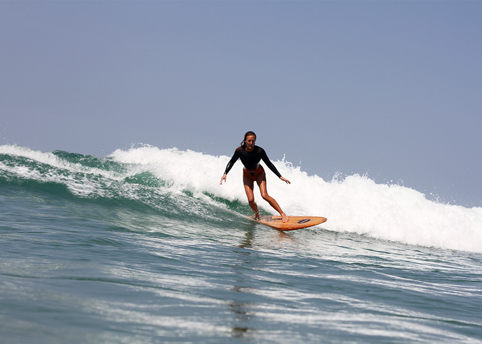 sarah bentley leans into a bottom turn on an otter surfboards wooden fish