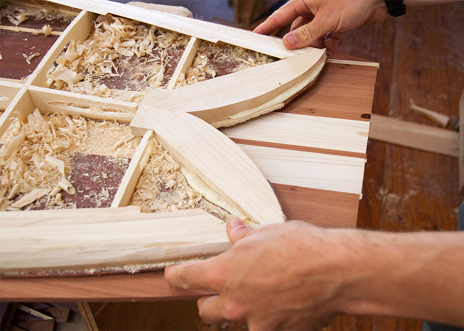 inside the tail of a wooden fish surfboard in the otter workshop