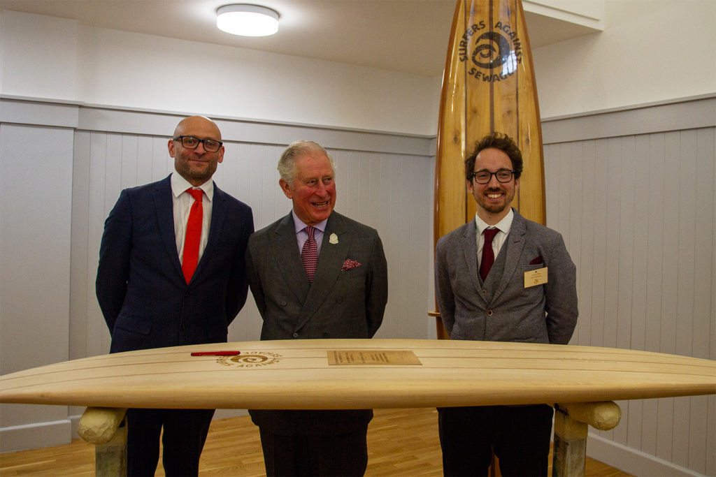 prince of wales prince charles duke of cornwall signs wooden surfboard to signify patronage for surfers against sewage hugo tagholm James Otter