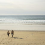 Chris and Larry walk to the waves in high summer with their Otter Wooden Surfboards at Gwithian in Cornwall. Riser and Coaster