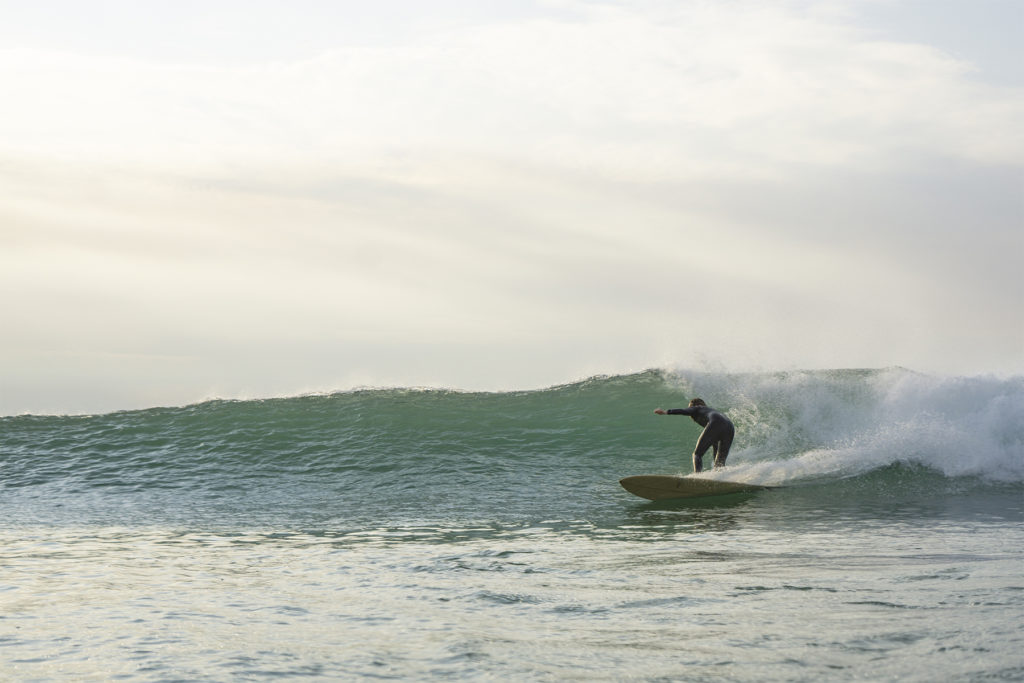Lawrence Stafford bottom turning on an Otter Wooden Coaster Surfboard at Gwithian in Cornwall