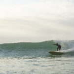 Lawrence Stafford bottom turning on an Otter Wooden Coaster Surfboard at Gwithian in Cornwall