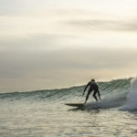 Lawrence Stafford drawn out bottom turn blur on an Otter Wooden Coaster Surfboard at Gwithian in Cornwall