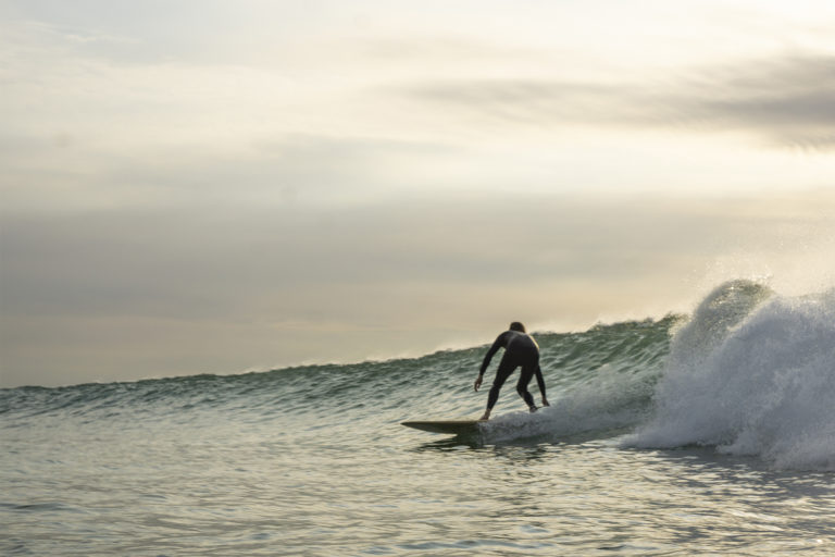 Lawrence Stafford drawn out bottom turn blur on an Otter Wooden Coaster Surfboard at Gwithian in Cornwall