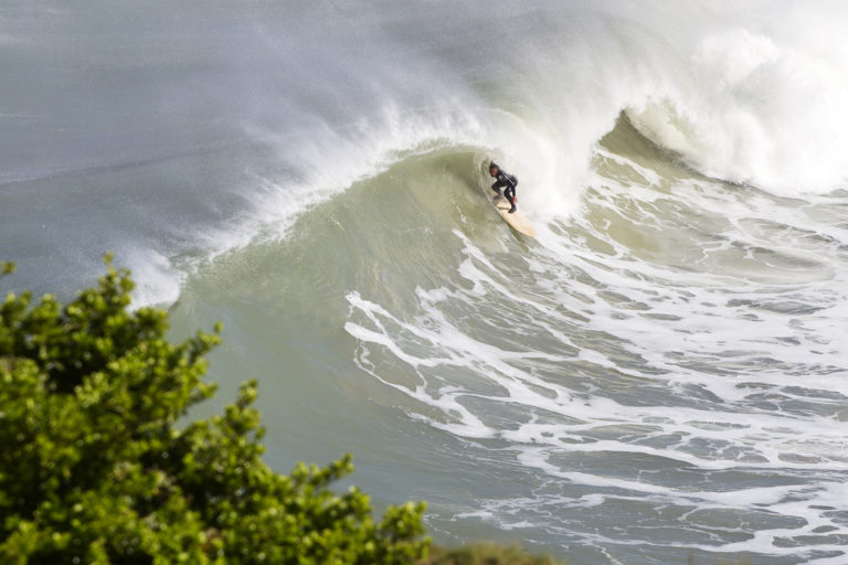Matt Smith takes cover on an Otter wooden surfboard coaster at St Agnes, Cornwall