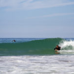Tony catches a wave on his wooden otter bellyboard