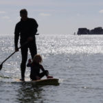 Otter surfboards wooden stand up paddle board on the water with father and daughter