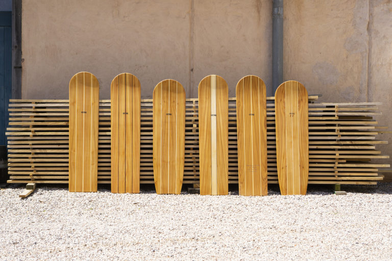 Full Line up of wooden bellyboards in front of the wood stack