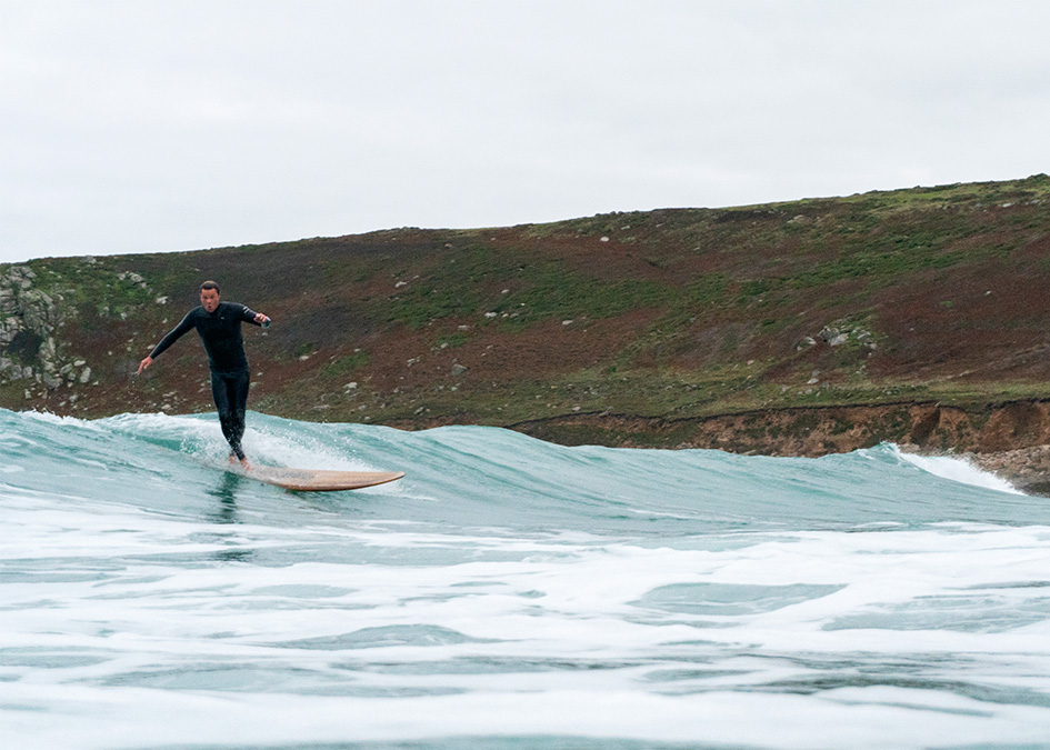 Sam Bleakley cross steps on an otter surfboards wooden longboard