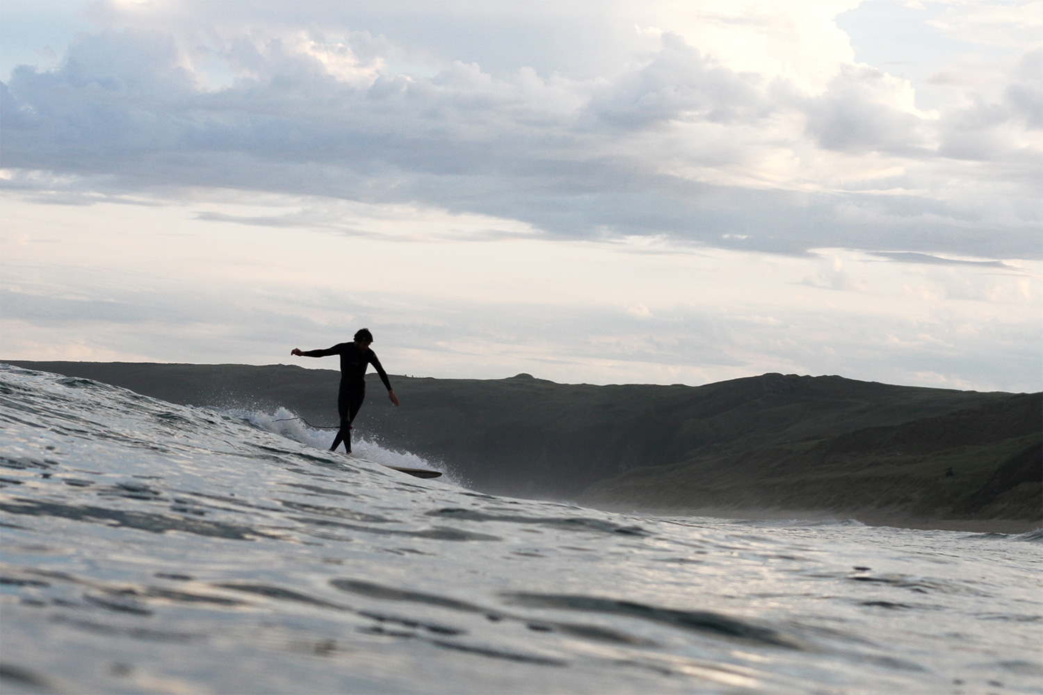 Chris Brunt Cross-steps on a wooden longboard surfboard