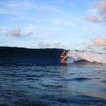 Sophie Hellyer on the beach in wetsuit with otter wooden surfboard in maldives seadar