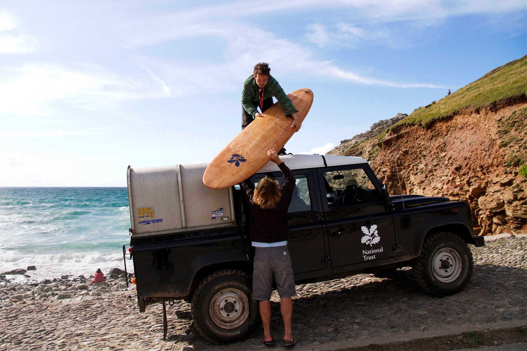 James Otter Nick Holden National Trust Wooden Surfboard Handover at Chapel Porth Landrover