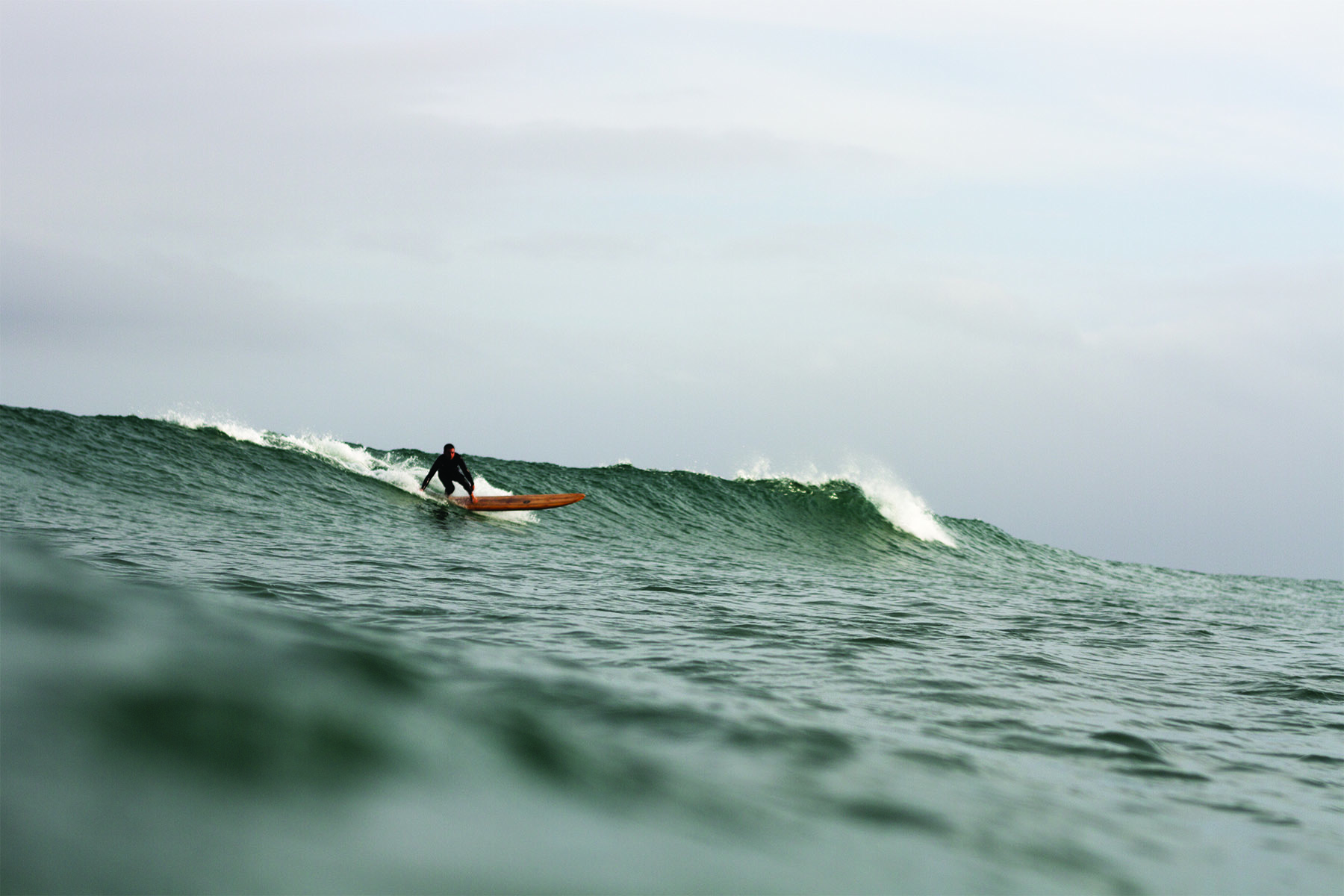 chris takes off on wooden surfboard otter pier longboard chapel porth