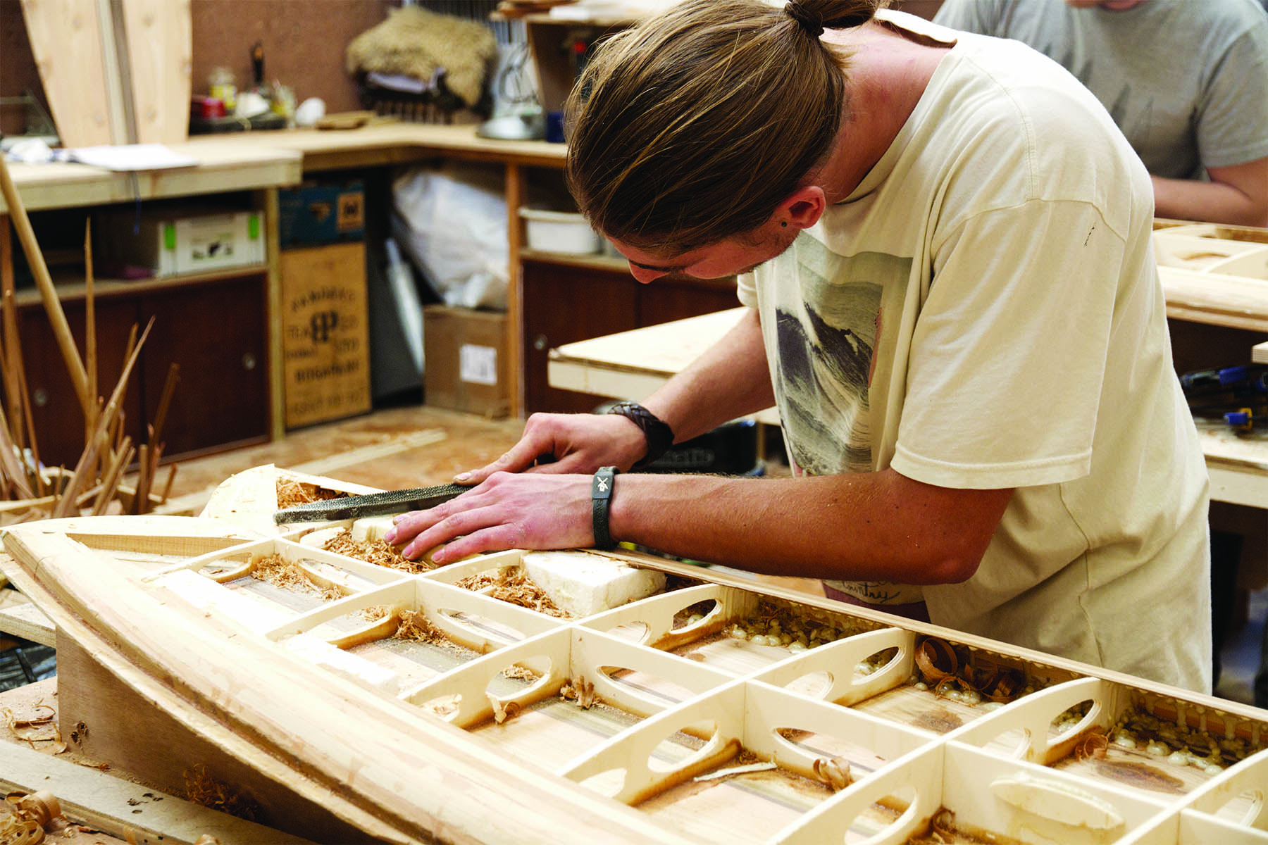 Claudio Pete and Patrick making wooden surfboards in the otter workshop claudio rail prep