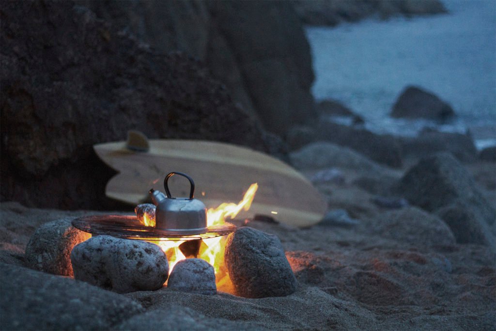 fetch otter wooden surfboard with campfire on the beach kettle