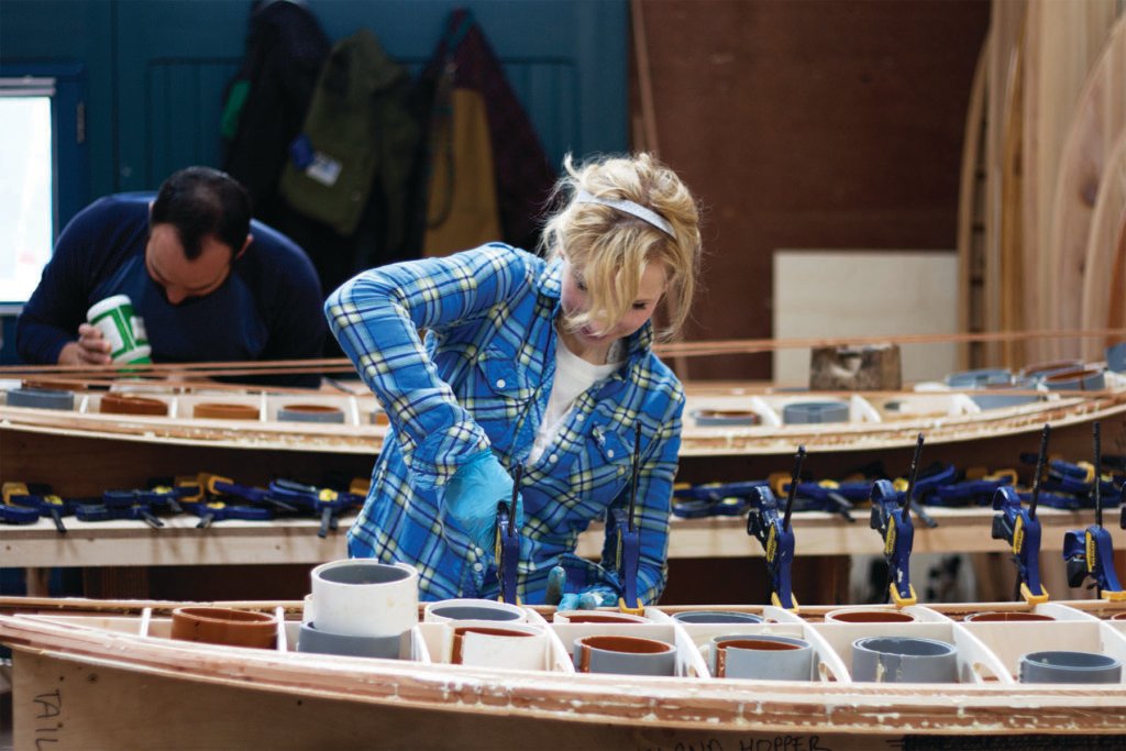 Kim and Shelby wooden surfboard making in the otter workshop in cornwall shelby fixing rail strips