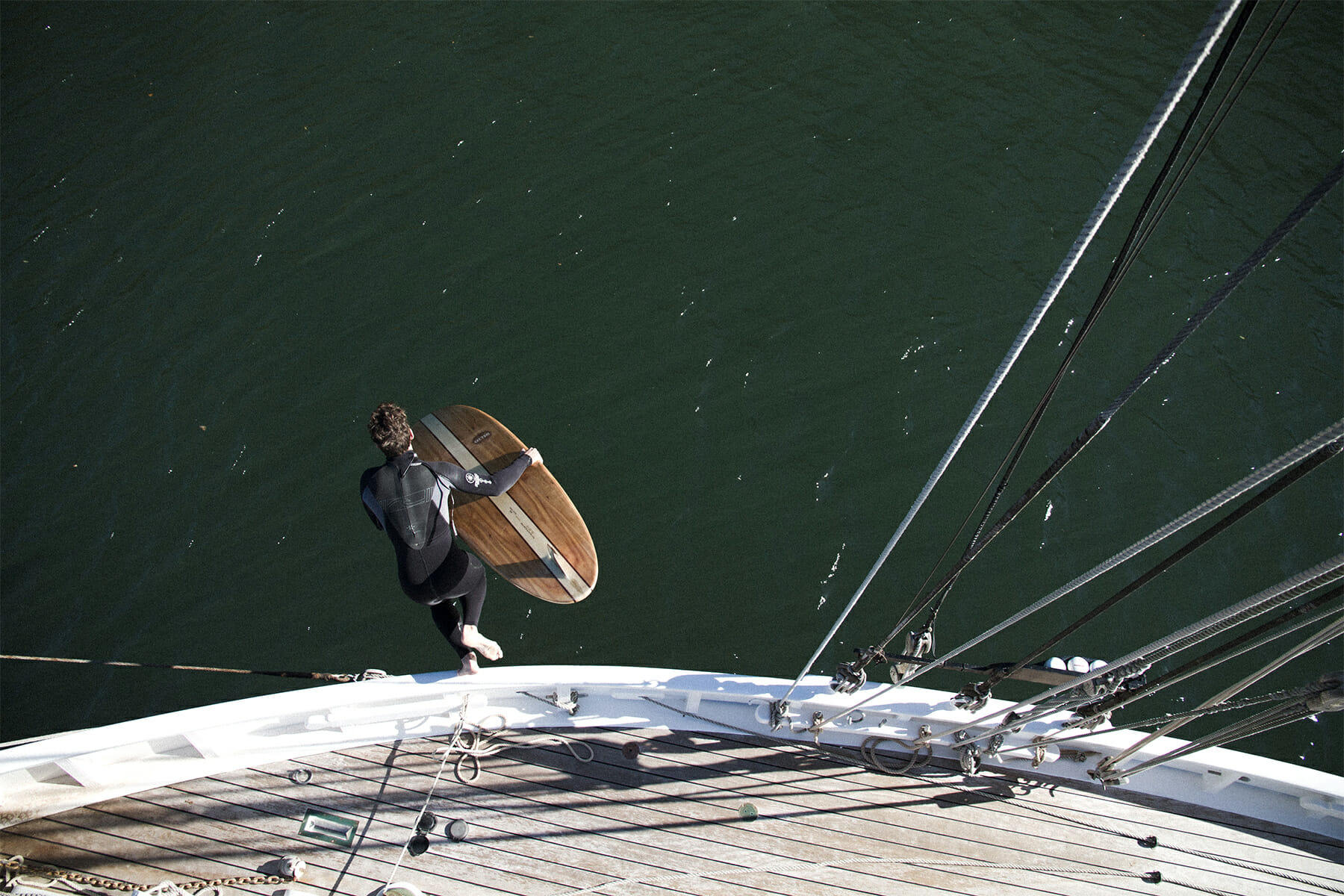 Otter wooden surfboard on gunwhale of wooden pilot cutter boat