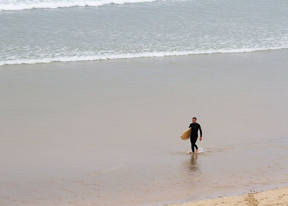 Otter wooden surfboard surfer walk beach