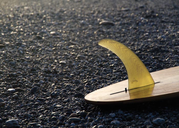 single fin wooden surfboard on the beach