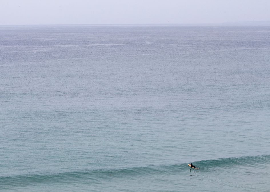 surfer paddling out