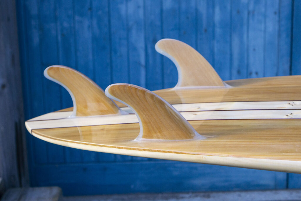 otter wooden surfboard glassed on fins