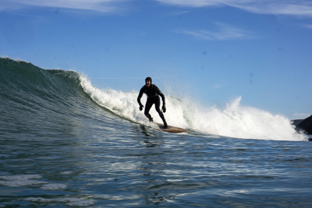 Surfer on a sustainable, hollow wooden surfboard.
