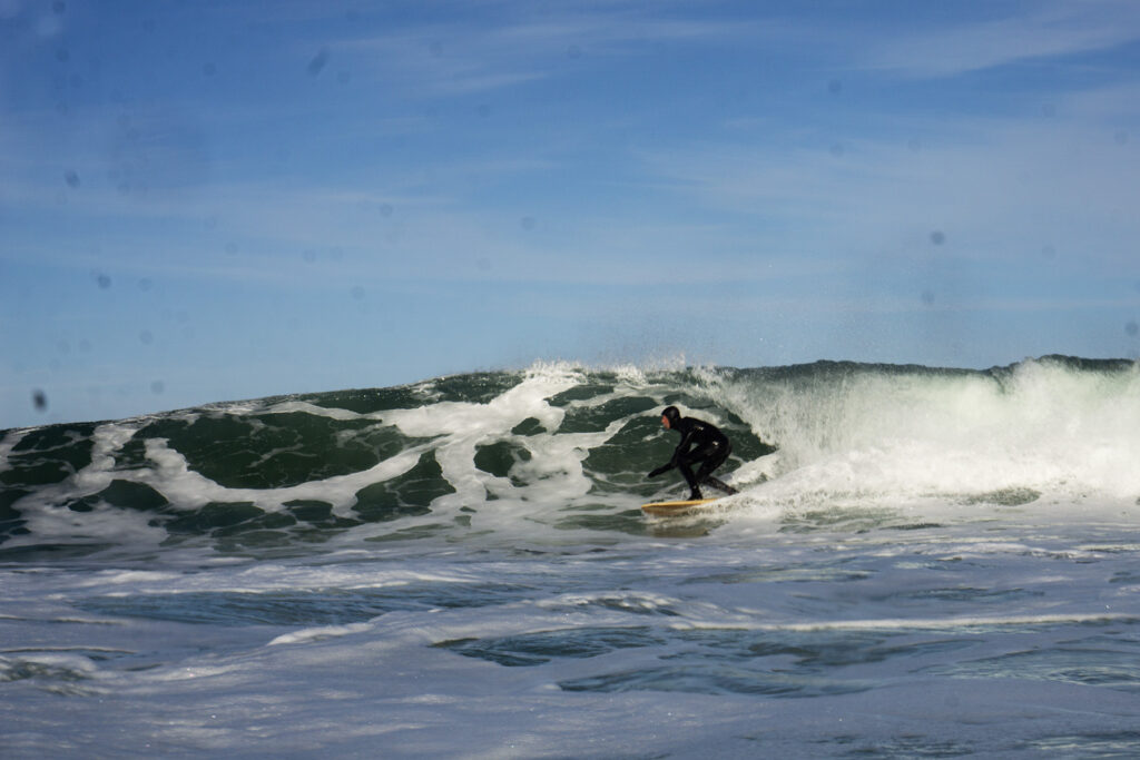Surfer on a sustainable, hollow wooden surfboard.