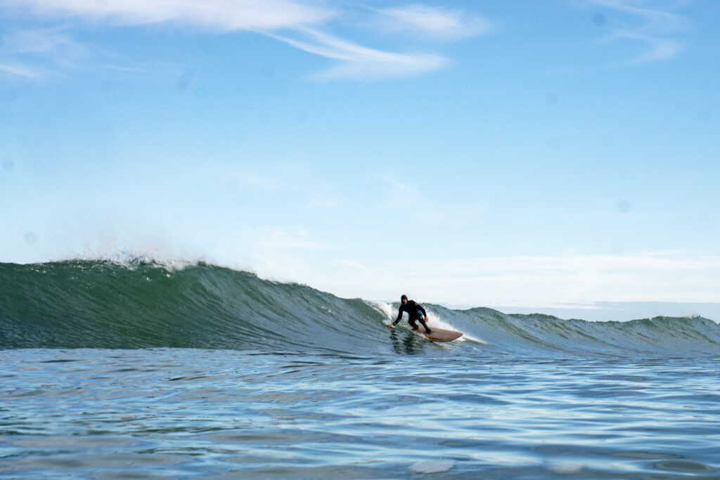 Surfer on a sustainable, hollow wooden surfboard.