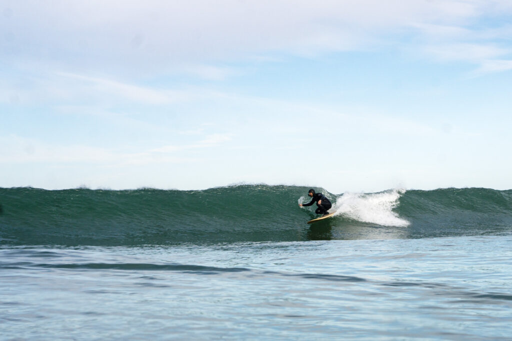 Surfer on a sustainable, hollow wooden surfboard.