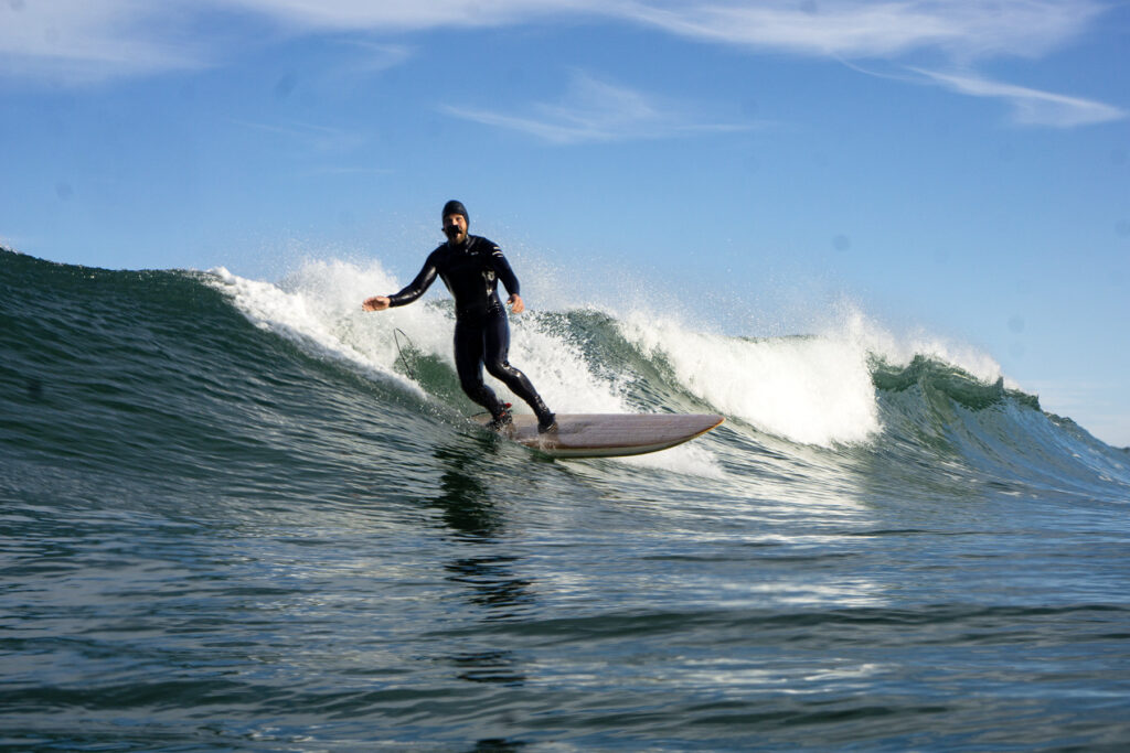 Surfer on a sustainable, hollow wooden surfboard.